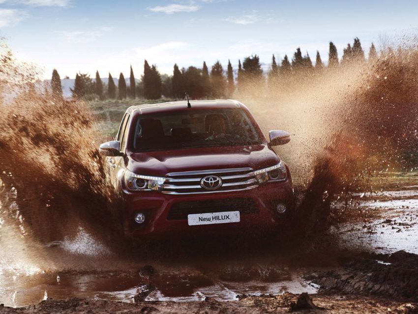 Toyota Hilux vinho passando por lamaçal